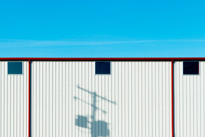 White wall, blue sky & red gutters